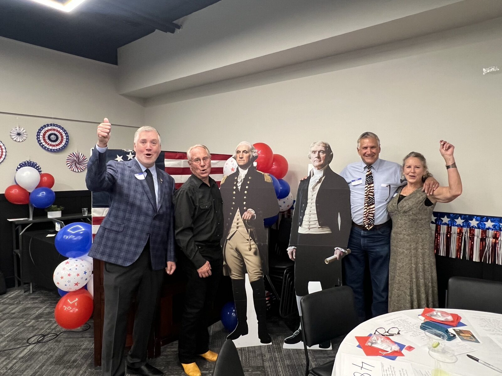Guests raise a cheer while posing with Founders cutouts at Celebrate America.