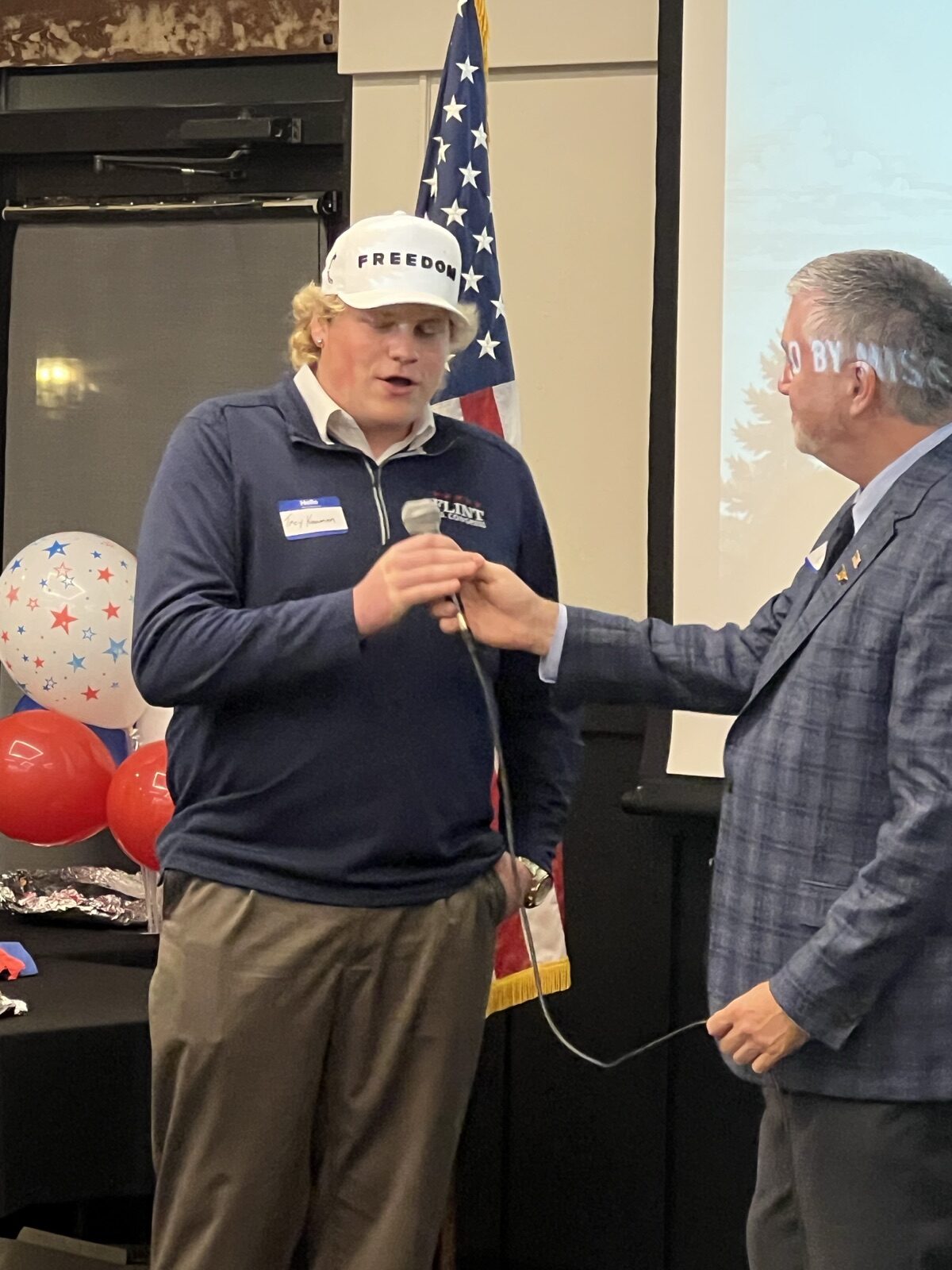 Chris Warden hands the microphone to a guest during the Celebrate America program.