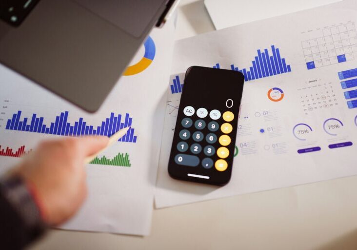a calculator sitting on top of a table next to a laptop